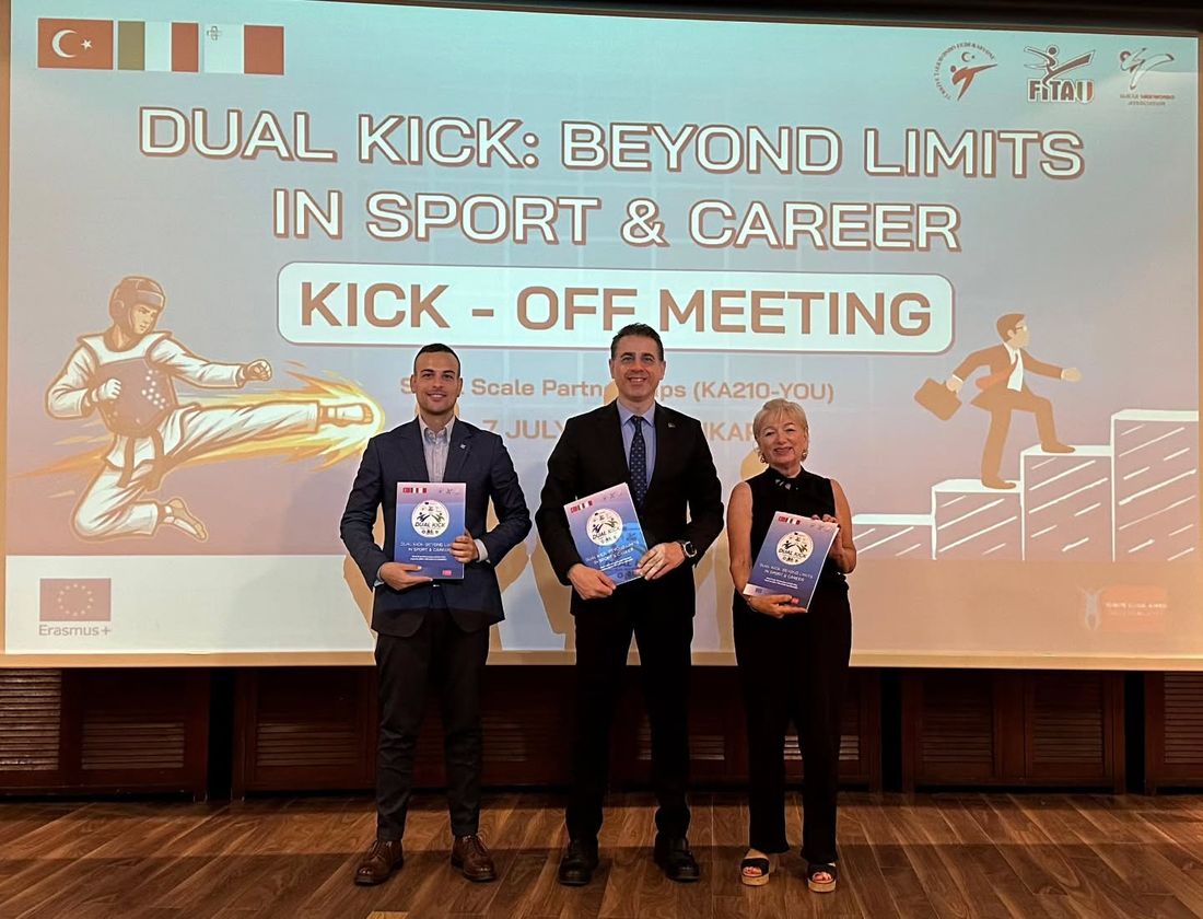 Dual Kick Kick-Off toplantısında proje ortaklarının temsilcileri, arkalarında projenin tanıtım sunumu.